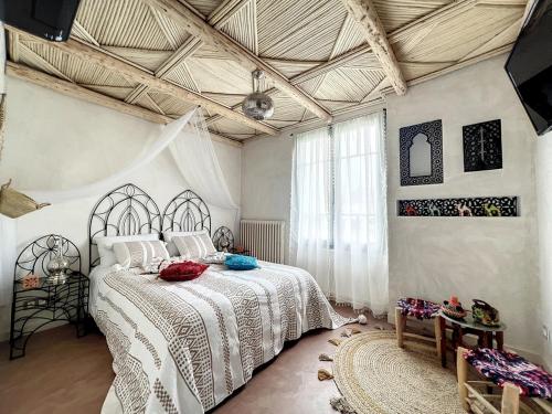 une chambre avec un lit avec un couvre-lit blanc dans l'établissement Les Gites de Beauval, à Saint-Aignan