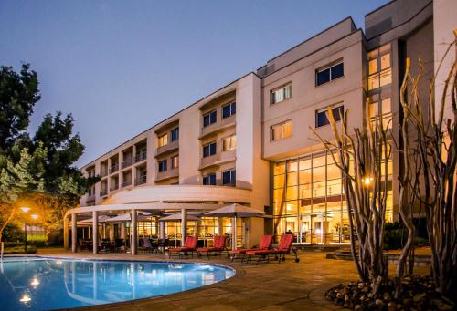 a hotel with a swimming pool in front of a building at Garden Court Eastgate in Johannesburg