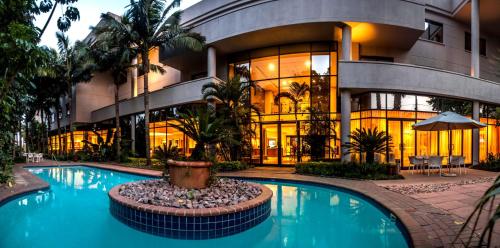 un bâtiment avec une piscine en face d'un bâtiment dans l'établissement Garden Court Hatfield, à Pretoria