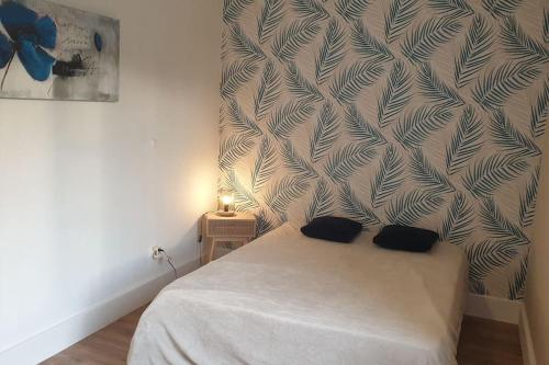 a bedroom with a bed and a wall at Bienvenue chez nous in Guérigny