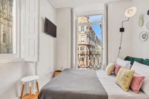 a bedroom with a bed with a view of a city at Host Wise - Lovely Shinny Flats with Balcony - Clerigos in Porto