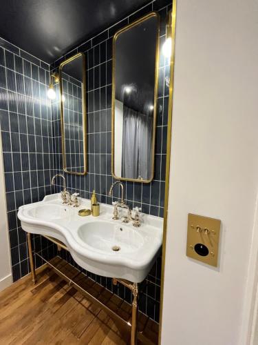 a bathroom with a sink and two mirrors at Loft me - Entre art deco et loft à l'americaine in Périgueux
