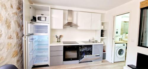 une cuisine avec des armoires blanches et une laveuse et une sécheuse dans l'établissement Chez Dominique - Migrainier nouveau 2-4 pers Center Antibes with AC, à Antibes