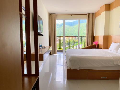 a bedroom with a bed and a balcony with a view at Conson Hotel in Con Dao