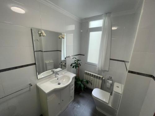 uma casa de banho branca com um lavatório e um WC em Piso cerca de las estaciones em Santander