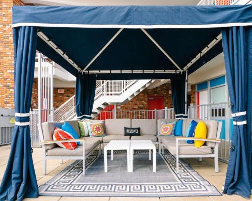 a blue canopy on a porch with couches and a table at Unscripted Durham, Part of JDV by Hyatt in Durham