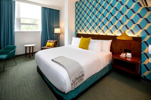 a hotel room with a large bed and a chair at Unscripted Durham, Part of JDV by Hyatt in Durham