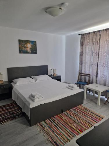 a bedroom with a large bed and a rug at Casa Ivana in Murighiol
