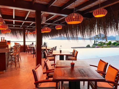 a restaurant with tables and chairs and a view of the ocean at Allium Bodrum Resort & Spa in Yalıkavak