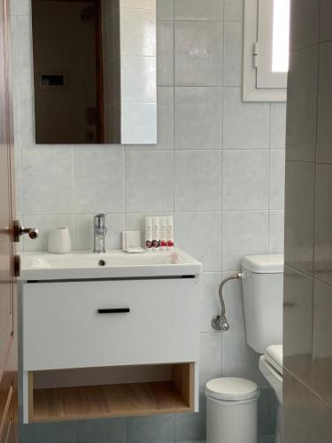 uma casa de banho branca com um lavatório e um WC em Giosifaki em Vári