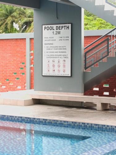 a sign on the side of a building with a swimming pool at Nasuha Homestay in Sandakan