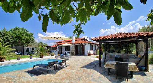 a backyard with a pool and a house at Casa Mary di Mare in Epanomi
