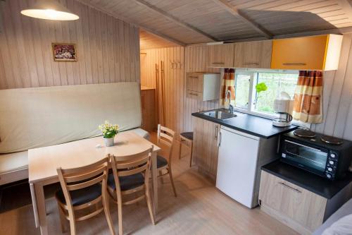 a kitchen and dining room with a table and a microwave at Randbøldal Camping & Cabins in Randbøl
