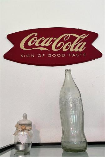 a cocacola sign and a glass bottle on a table at SleepWell in Valganna in Valganna