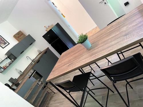a kitchen with a wooden bar with two black chairs at SleepWell in Valganna in Valganna