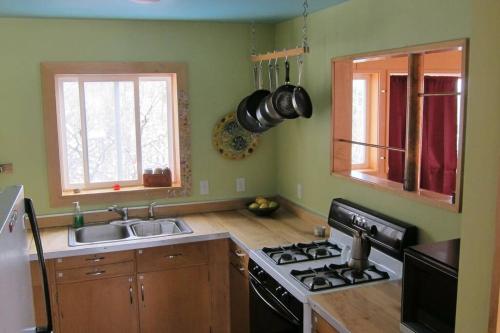 a kitchen with a stove and a sink at Towerhouse - Modern Cabin @ 8,000ft in Wanship