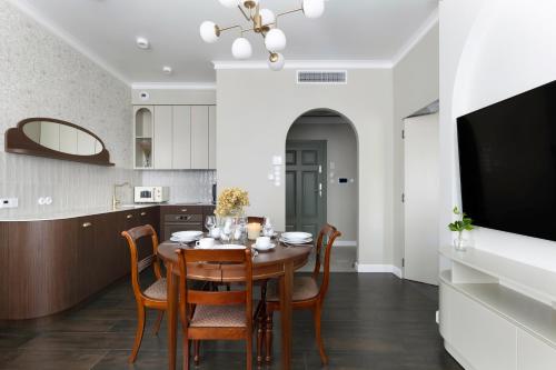 a kitchen and dining room with a wooden table and chairs at Willa Szwarc by Elite Apartments in Sopot