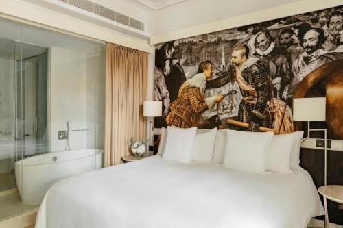 a bedroom with a large bed and a painting on the wall at Palacio de los Duques Gran Meliá - The Leading Hotels of the World in Madrid
