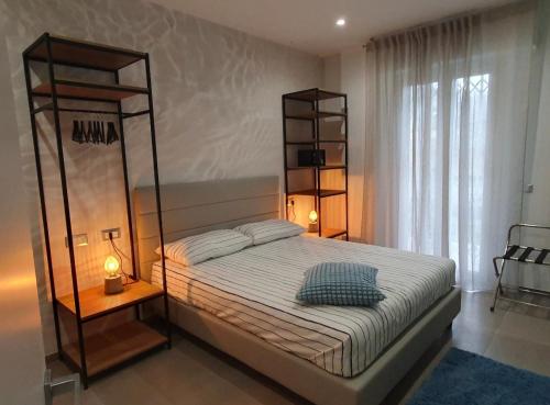 a bedroom with a large bed and two shelves at Playa degli Angeli Grecale in Gabicce Mare
