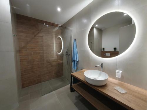 ein Bad mit einem Waschbecken und einer Dusche mit einem Spiegel in der Unterkunft Playa degli Angeli Grecale in Gabicce Mare