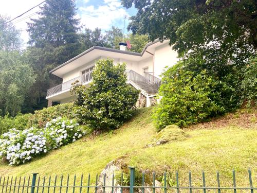 una casa en la cima de una colina con flores en SleepWell in Valganna, en Valganna