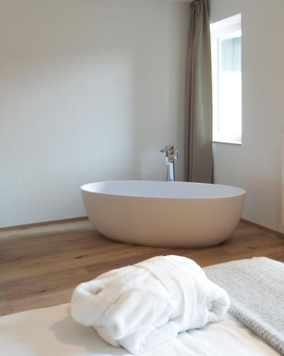 a bathroom with a white bath tub on a wooden floor at Anett hotel in Vipiteno