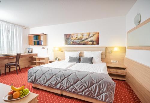 シュトゥットガルトにあるApart Business Hotelのベッドとデスクが備わるホテルルームです。