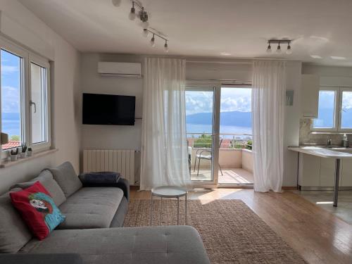a living room with a couch and a view of the ocean at Peachy House in Rijeka
