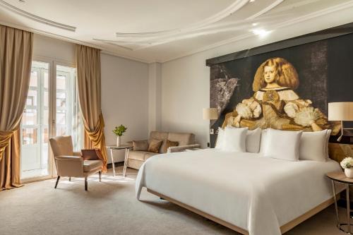 ein Schlafzimmer mit einem großen Bett und ein Bild einer Frau in der Unterkunft Palacio de los Duques Gran Meliá - The Leading Hotels of the World in Madrid