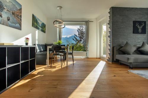 una cucina e un soggiorno con tavolo e divano di Modern Innsbruck Mountain Apartment I Free Parking a Innsbruck