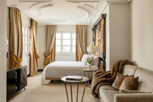 a hotel room with a bed and a couch at Palacio de los Duques Gran Meliá - The Leading Hotels of the World in Madrid
