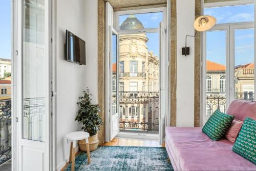 a living room with a couch and a view of a building at Host Wise - Lovely Shinny Flats with Balcony - Clerigos in Porto