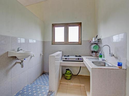 un pequeño baño blanco con lavabo y lavabo en OYO 92617 Omahku Homestay Hostel, en Yogyakarta