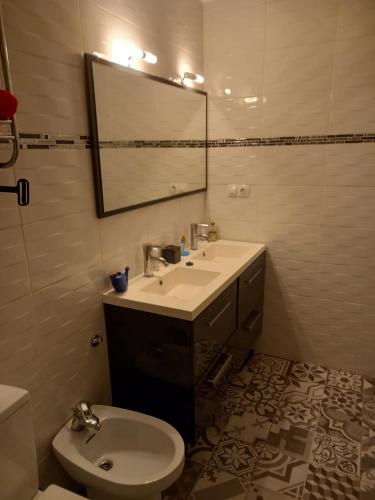 a bathroom with a sink and a toilet and a mirror at Monleon Villa a 10 minutos de la playa 2 parking gratuito in Roses