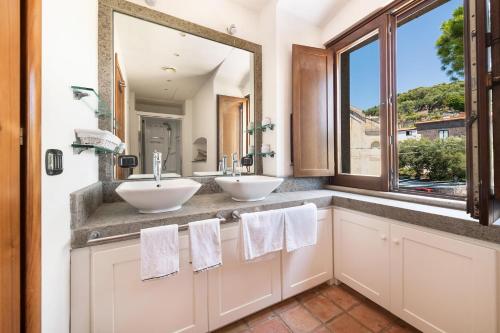 een badkamer met 2 wastafels en een groot raam bij Torre del Saraceno in Massa Lubrense