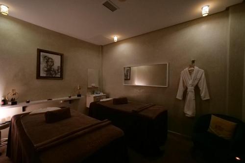 a room with two beds and a robe hanging on a wall at El Olivar Palace Marrakech All Inclusive, Aquapark & SPA in Marrakech