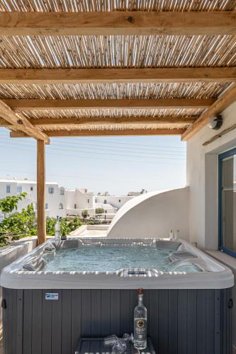 a hot tub on a patio with a wooden ceiling at Naxian Queen Luxury Villas & Suites in Agia Anna Naxos