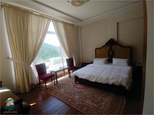 a bedroom with a bed and a large window at Himalaya Villas in Murree