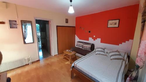 een slaapkamer met een bed en een rode muur bij Y.M.Apartment in Rhodos-stad