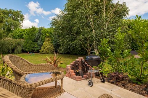 a grill and chairs on a patio in a garden at Elsie's Retreat in Durham