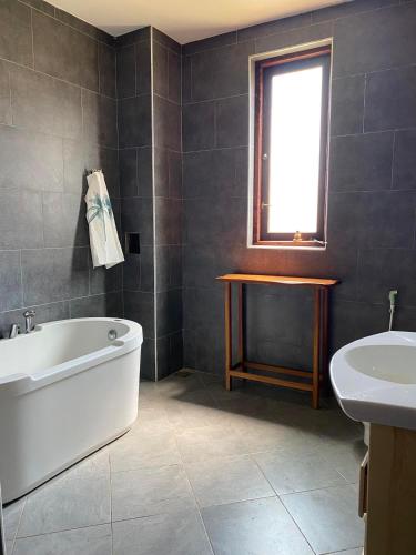 a bathroom with a white tub and a sink at Spice of Ceylon in Chilaw