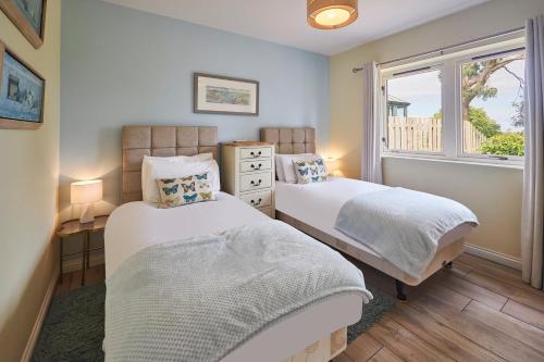 two beds in a room with a window at Host & Stay - Sandpipers in Belford