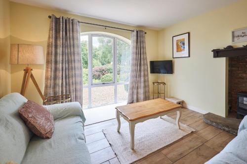 a living room with a couch and a table and a window at Host & Stay - Sandpipers in Belford