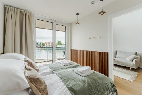 a bedroom with a bed and a large window at Penthouse Lighthouse Mrzeżyno SurfingBird in Mrzeżyno