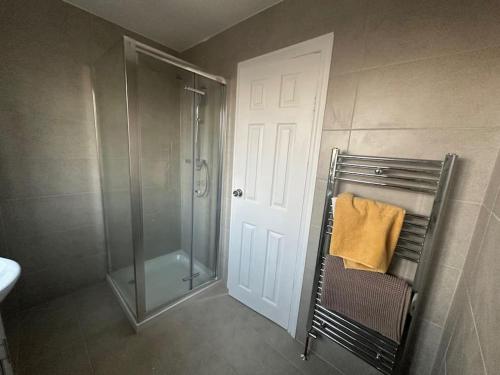 a bathroom with a shower and a towel on a rack at Modern & Spacious Terrace House in Friern Barnet