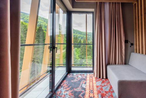 a room with a couch and a large window at Hotel Nomad in Bjelašnica