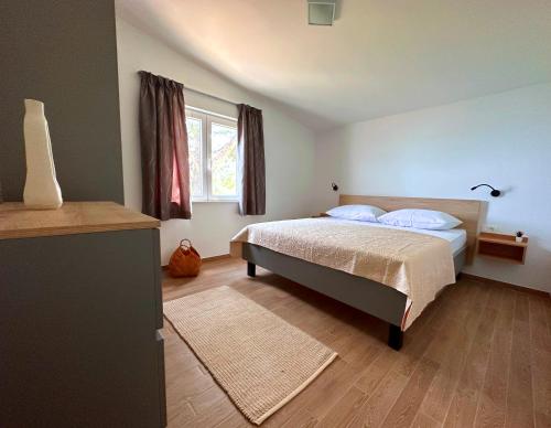 a bedroom with a bed and a window at La Isla in Tkon
