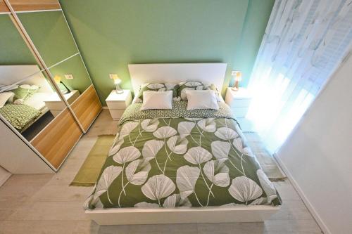 - une chambre dotée d'un lit avec une couverture verte et blanche dans l'établissement Blue&Green Apartments, à Zadar
