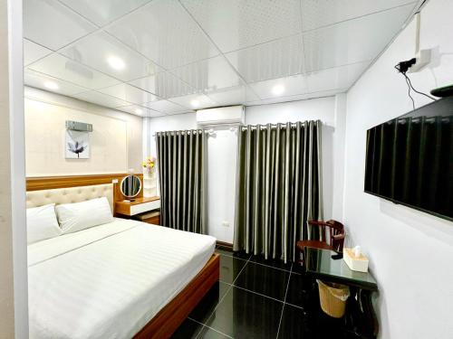 a bedroom with a bed and black and white curtains at Sen Hotel My Dinh Song Da 미딩 in Hanoi