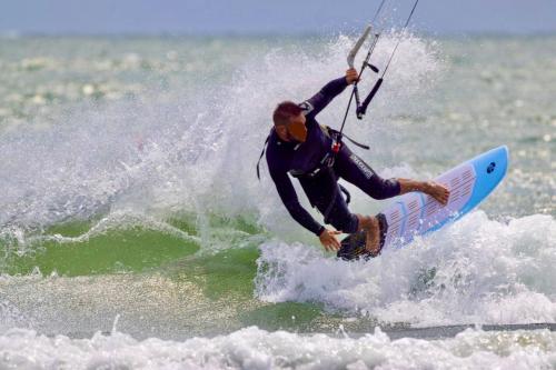 Un uomo che cavalca un'onda su una tavola da surf nell'oceano di Ca' Memi - Relaxing Stay in Chioggia a Chioggia